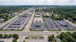 An elevated aerial view of several dealership lots in a metropolitan area