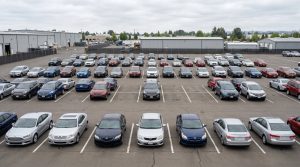 A wholesale auto auction lot with visibly sparse inventory and several empty parking spaces representing the off-lease vehicle shortage